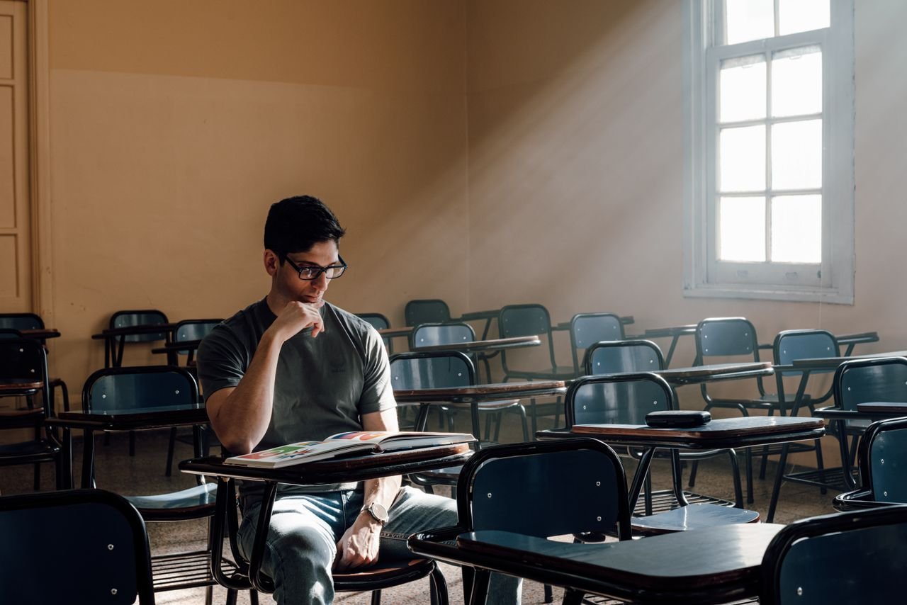 services-02 A student studies alone in a sunlit Buenos Aires classroom, portraying university life.