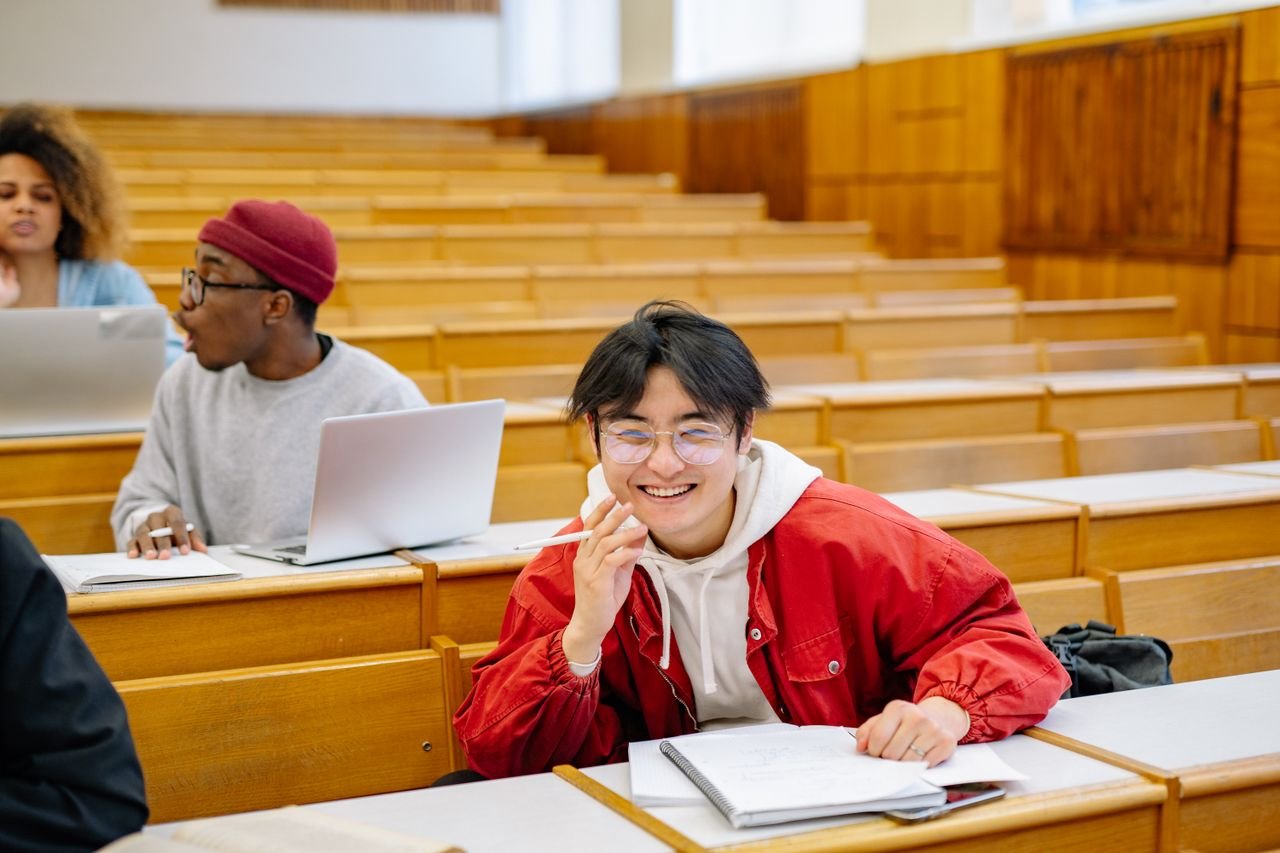 services-03 Smiling students studying together in a university lecture hall, promoting diversity and collaboration.